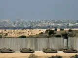 Al acecho. Un convoy de tanques tanques israelíes espera tras el muro de separación las órdenes para entrar en la franja de Gaza. El Gobierno israelí ha aprobado una escalada en las operaciones sobre territorios palestinos, que comenzaron tras el secuestro de un soldado israelí.