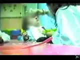 Una cuidadora tapa la nariz de una niña para que se coma su vómito.(T5)