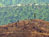 Colina desnuda de vegetación con un pueblo de agricultores de arroz y opio al fondo en Myanmar (Birmania), en la región autónoma de Wa, en el Triángulo Dorado cercada a la frontera con China, en abril de 2004.