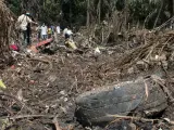 Trabajadores de los equipos de rescate buscan entre los restos del avión siniestrado de Kenya Airways en Doula. (EFE).