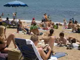 La playa de la Barceloneta se llena de ba&ntilde;istas.