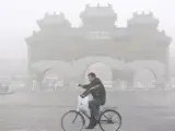 Fotografía de archivo del 21 de febrero del 2007 que muestra a un hombre paseando en bicicleta entre una densa niebla en Pekín (EFE/Diego Azubel)
