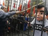 Un hombre golpea a un muñeco que representa a Fujimori en una manifestación de trabajadores despedidos durante su mandato, frente a la embajada de Chile en Lima. (REUTERS).