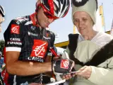 El ciclista murciano Alejandro Valverde firma autógrafos a unas mujeres disfrazadas durante una etapa del Tour 2007 (EFE).