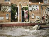 Una mujer, a la puerta de su casa en Almería, contempla los destrozos causados por el temporal.