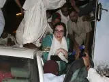 Benazir Bhutto es sacada de un autobús blindado momentos después de las dos explosiones.