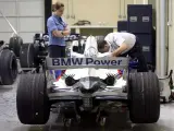 Una comisaria de la FIA supervisa a un mecánico de BMW