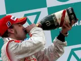 Fernando Alonso bebe champán en el podio de Sepang.