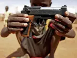Un niño sujeta la réplica de una pistola en Darfur. (Stuart Price / Reuters).