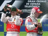 Los pilotos Lewis Hamilton y Fernando Alonso, antiguos compañeros en McLaren, celebran con champán su segundo y tercer lugar respectivamente en el pasado Gran Premio de España.