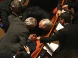 El senado democristiano Nuccio Cusumano es asistido tras sufrir un desmayo en el Senado italiano, tras la bronca. Los enfrentamientos comenzaron cuando Cusumano, uno de los tres senadores del UDEUR (el partido que ha abandonado la coalición en el poder y desatado la crisis de Gobierno) dijo que votará a favor de Prodi, contra la decisión del partido.