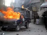 Un vehículo de la policía fotografiado después de que miembros del movimiento opositor APDM le prendieran fuego en Quetta, Pakistán. (EFE)