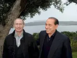 Silvio Berlusconi conversa con el presidente ruso en funciones, Vladimir Putin. (EFE)