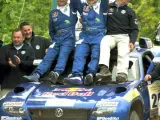 El ganador en la categoría de coches, el español Carlos Sainz (c), acompañado de su copiloto, el francés Michel Perin (i), celebran la conquista del Rally Centroeuropeo, el primer rally del Dakar Series. (EFE)