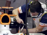 Mimos al R28. Un mecánico de Renault lima uno de los alerones del monoplaza de Fernando Alonso al inicio de la tercera sesión de entrenamientos libres. (EFE)