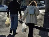 Dos consumidores con sus bolsas de pl&aacute;stico.