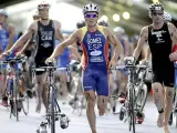 Javier Gómez Noya (c) en la transición de la natación a la prueba del ciclismo de una prueba (AP).