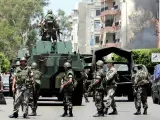 Soldados libaneses hacen guardia en una calle cercana a una tienda que ha sido quemada por un seguidor del partido libanés de la mayoría, en Beirut. (EFE)