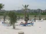 Un grupo de jóvenes, tomando el sol en la playa fluvial.