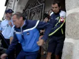 El ciclista español Manuel Beltrán (d), del equipo Liquigas, sale escoltado del Hotel des Voyageurs en Le Rouget, Francia. (EFE)