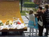 Los familiares de las víctimas depositan flores en el monumento levantado en su memoria.