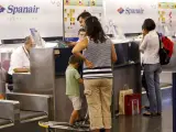 Varias personas facturan su equipaje en los mostradores de Spanair de la T-2 del aeropuerto madrileño de Barajas (ARCHIVO).