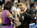 El senador por Illinois y candidato demócrata a la Presidencia de Estados Unidos, Barack Obama, se da un golpe de nudillos con su esposa Michelle Obama con un vestido liso violeta.