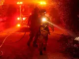 Miembros del cuerpo de bomberos trabajan en las labores de extinción de un incendio originado en el condado de Santa Barbara, en el sur de California. El siniestro avanza sin control y ya ha calcinado varias viviendas en Montecito, un área de lujo donde tienen residencia famosos como Michael Douglas.