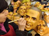 Una mujer pinta una careta de Obama en Brasil.