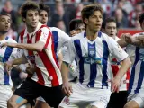 Jugadores del Athletic de Bilbao y del Recreativo de Huelva siguen la trayectoria del balón durante el partido. (EFE)
