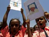 Un grupo de niños sudaneses sostiene fotografías del presidente al-Bashir frente a las oficinas de la ONU.