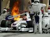 Mecánicos de BMW Sauber apagan un pequeño incendio en el coche del piloto polaco Robert Kubica.