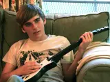 Un muchacho juega al juego Guitar Hero.