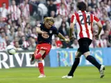 El centrocampista del Athletic, Javi Martinez (d) observa el disparo del delantero uruguayo Forlan, del Atlético.