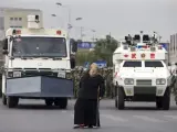 Una mujer uigur, delante de dos vehículos militares en Urumqi (Xinjiang, China), durante las protestas.