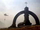 Un helicóptero suelta agua en el Puerto del Pico de Ávila durante los trabajos de extinción del incendio.