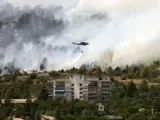 Un helicóptero descarga su depósito de agua en el incendio de Collado Mediano.