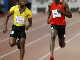 Los atletas jamaicanos Usain Bolt (d) y Asafa Powell (i), compiten en la carrera de los 100 metros lisos masculinos en Zúrich.