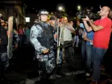 Manifestantes y periodistas esperan la salida de Manuel Zelaya ante un fuerte dispositivo policial.