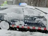 Un coche patrulla de los Mossos d'Esquadra, cubierto por la nieve.