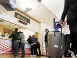 n grupo de pasajeros intenta canjear sus billetes en el aeropuerto de Noáin, en Pamplona, antes de la reapertura.