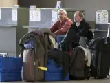 Dos pasajeros esperan en los mostradores de embarque en el aeropuerto de Sevilla.