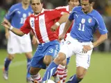 El jugador paraguayo Claudio Morel (i) lucha por el balón con el italiano Alberto Gilardino (d).
