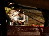 Una forense toma las huellas dactilares a un cadáver en el andén de Castelldefels Platja.