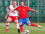 El jugador español Juan Mata (d) controla el balón ante el polaco Adam Marciniak durante el partido Polonia-España.