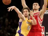 Pau Gasol, a la izquierda, pasa el balón ante la imponente presencia de Yao Ming.