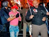 Varios policías intentan controlar a un grupo de sindicalistas en la puerta de la sede central de Correos de Valencia.