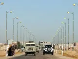 Mujeres saharauis intentan conseguir transporte para dirigirse hacia el campamento de desplazados saharauis Gdeim Izi en la carretera que lleva del El Aaiún.