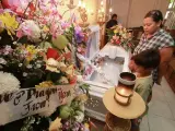 La filipina Engrid Ehavez y sus hijos, observan los restos del actor filipino Kirk Abella, durante su velatorio en la ciudad de Cebu, Filipinas.
