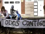 Dos jóvenes colocan una pancarta de apoyo a la atleta Marta Domínguez ante su vivienda, en Palencia.